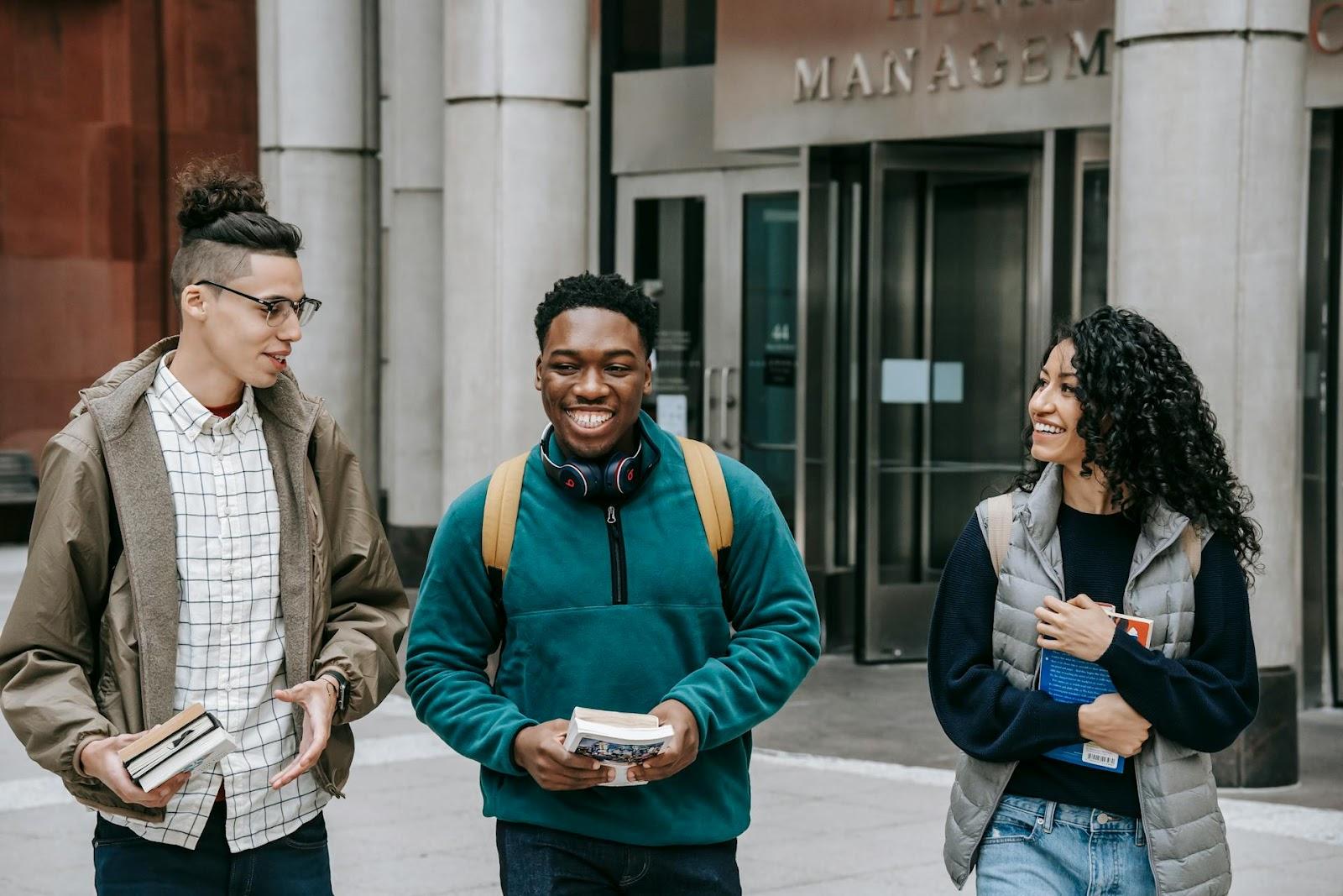Diverse group of students smiling outside a university building
